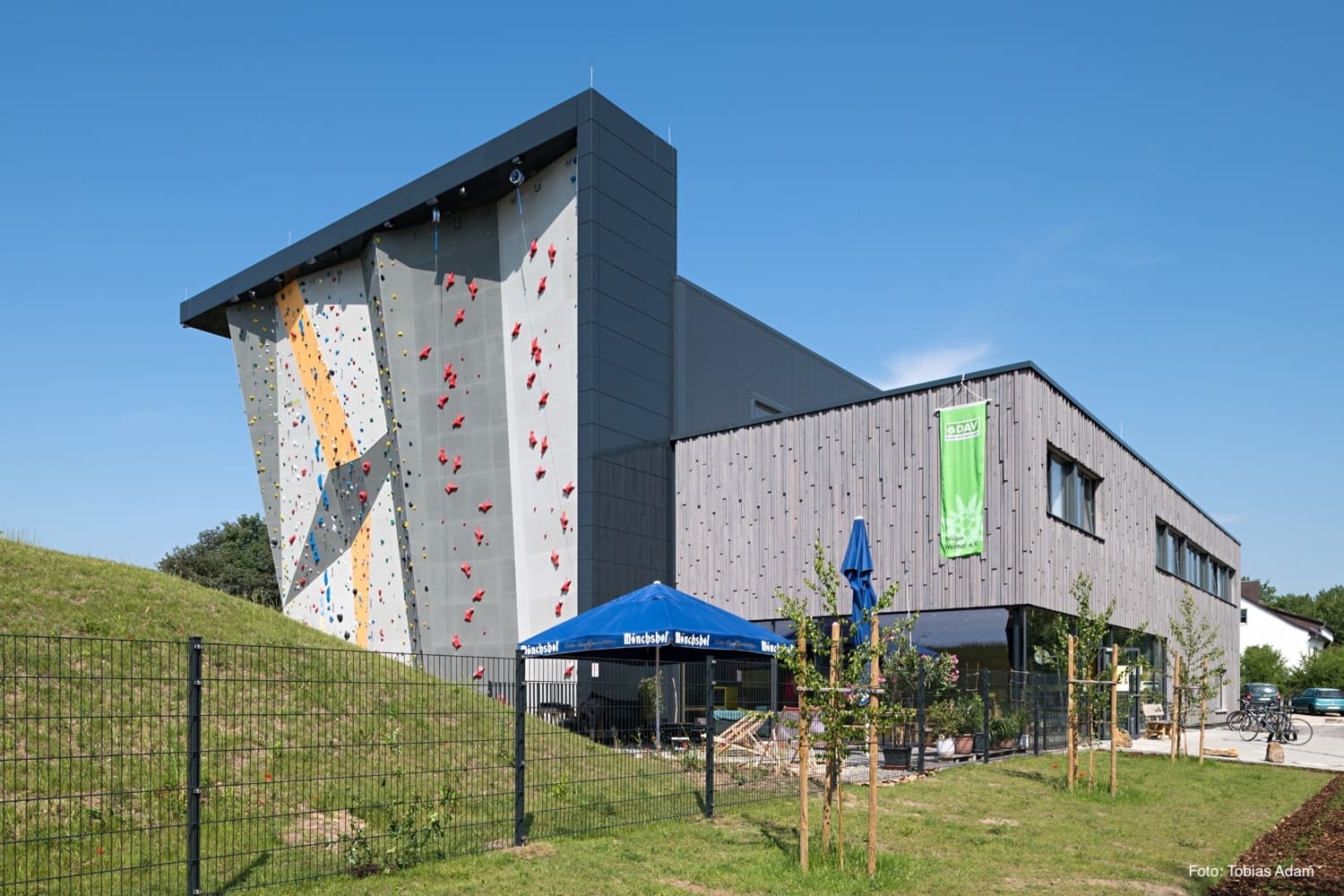 A building with a large rock wall on the side of it.