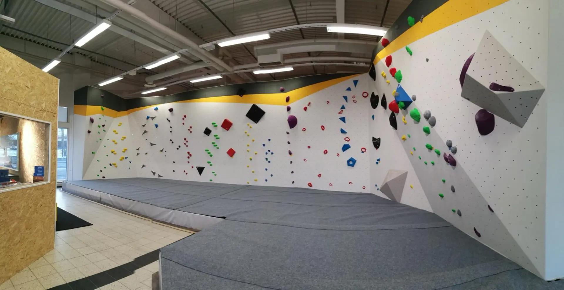 A large indoor climbing wall with many different colors.