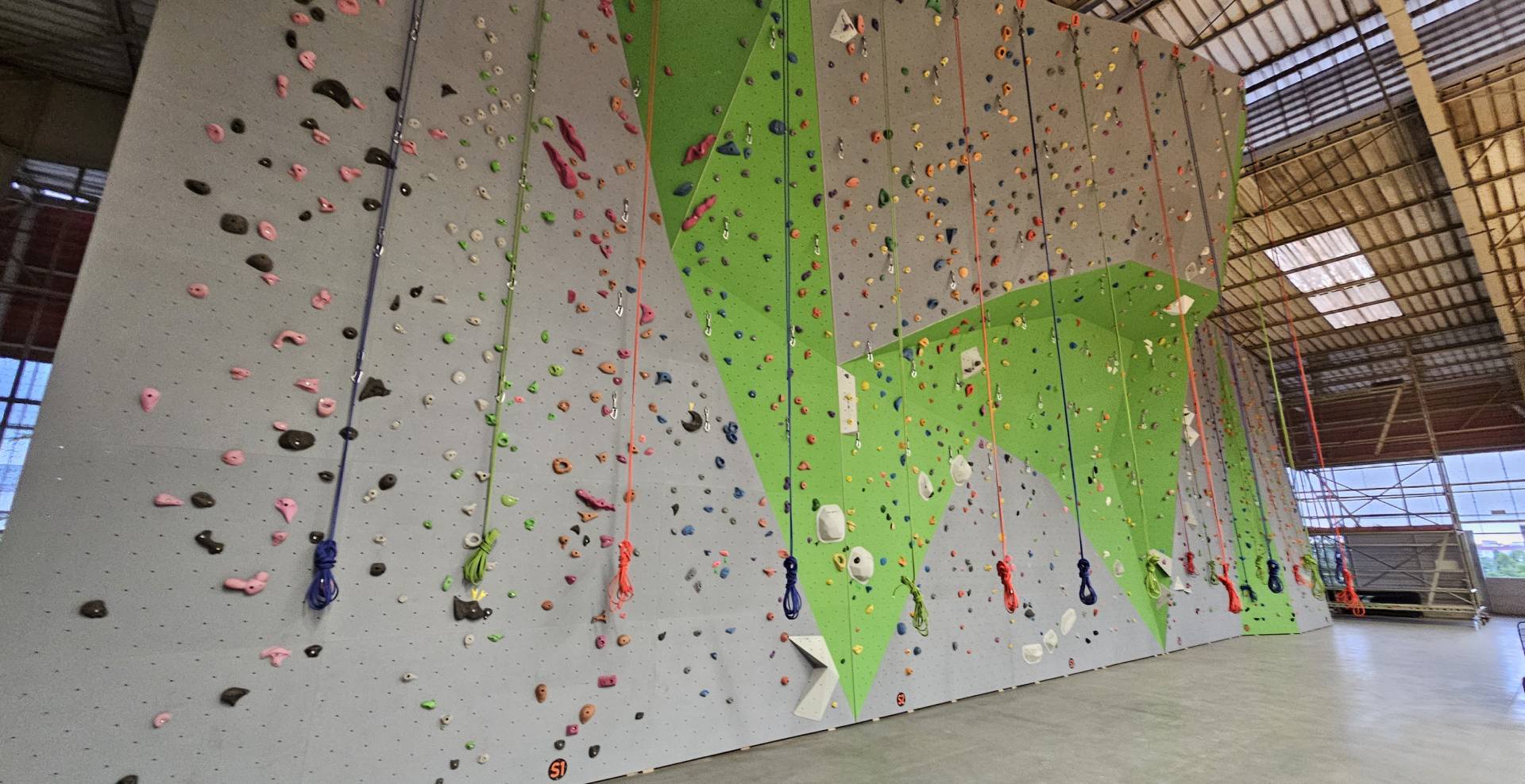 A wall with many different colored climbing holds.